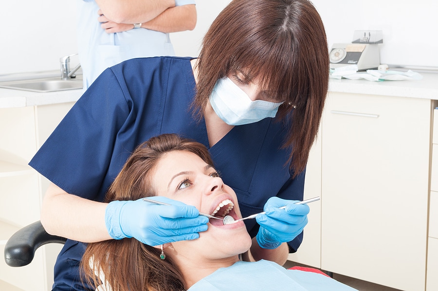 Close-up photo of a female dental hygienist performing a cleaning on a patient